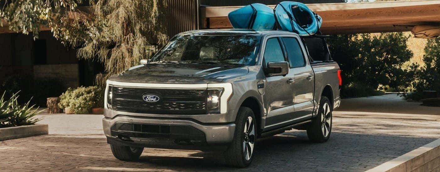A grey 2024 Ford F-150 Lightning for sale near San Jose parked on a driveway.