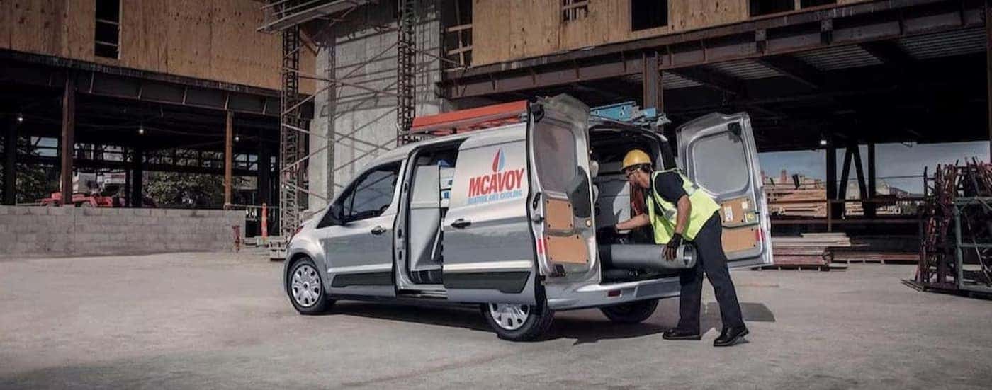 A silver 2023 Transit Connect Cargo Van on a construction site.