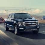 Black 2023 Ford F-150 driving down a highway