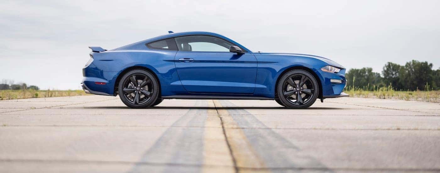 A blue 2022 Ford Mustang from the side after leaving a car dealership.