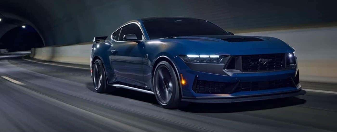 Blue 2024 Ford Mustang Dark Horse driving through a tunnel