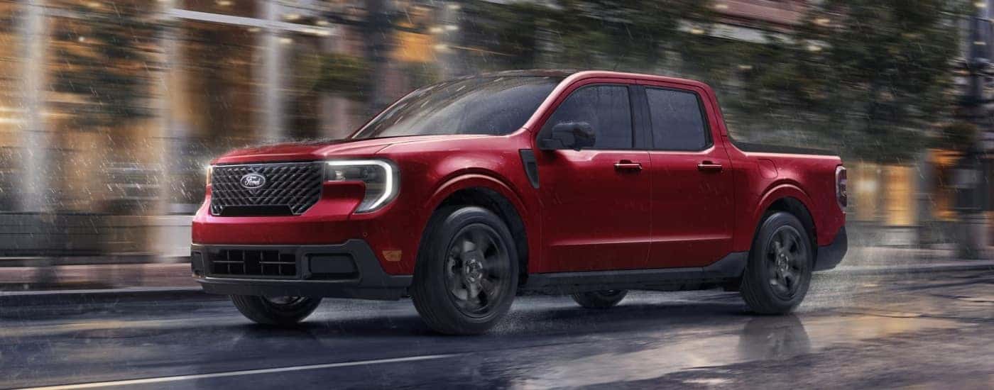 Red 2025 Ford Maverick driving down a city street.