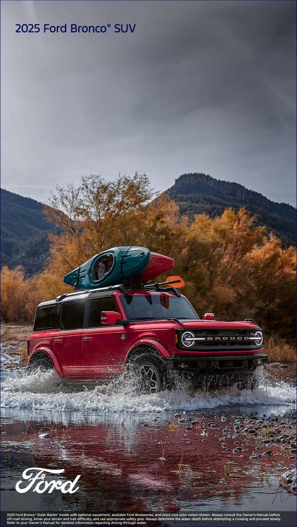 Red Ford Bronco driving through water