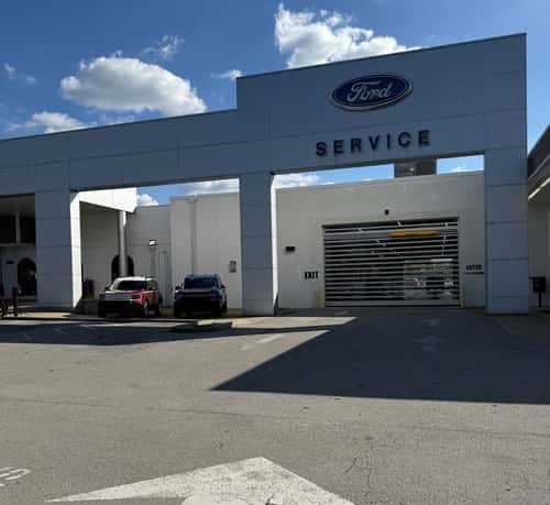 Mechanic working in engine bay of Ford vehicle