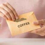 Putting money into an envelope for saving coffee
