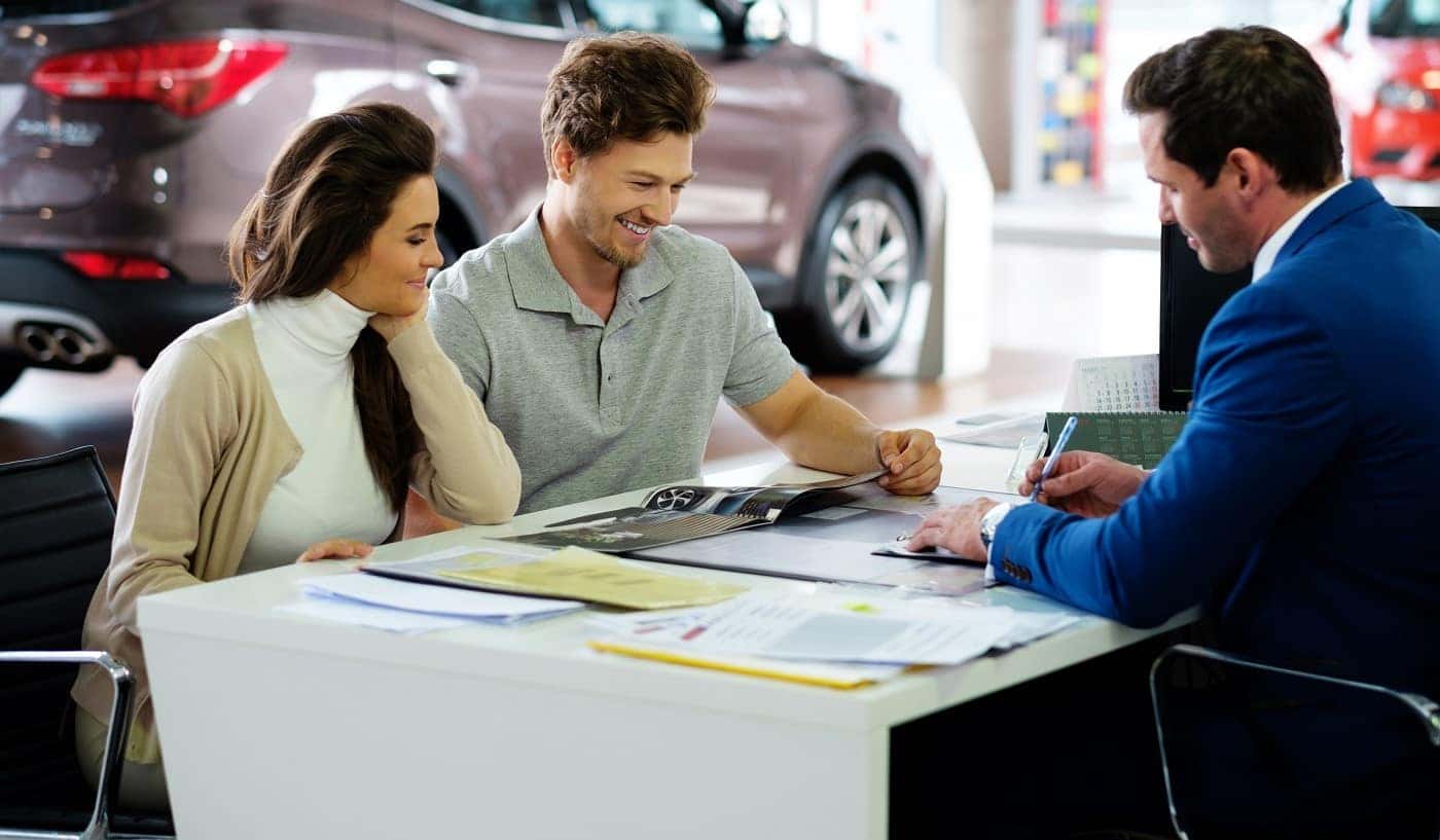 Couple discussing finance options for new Ford vehicle with finance team member