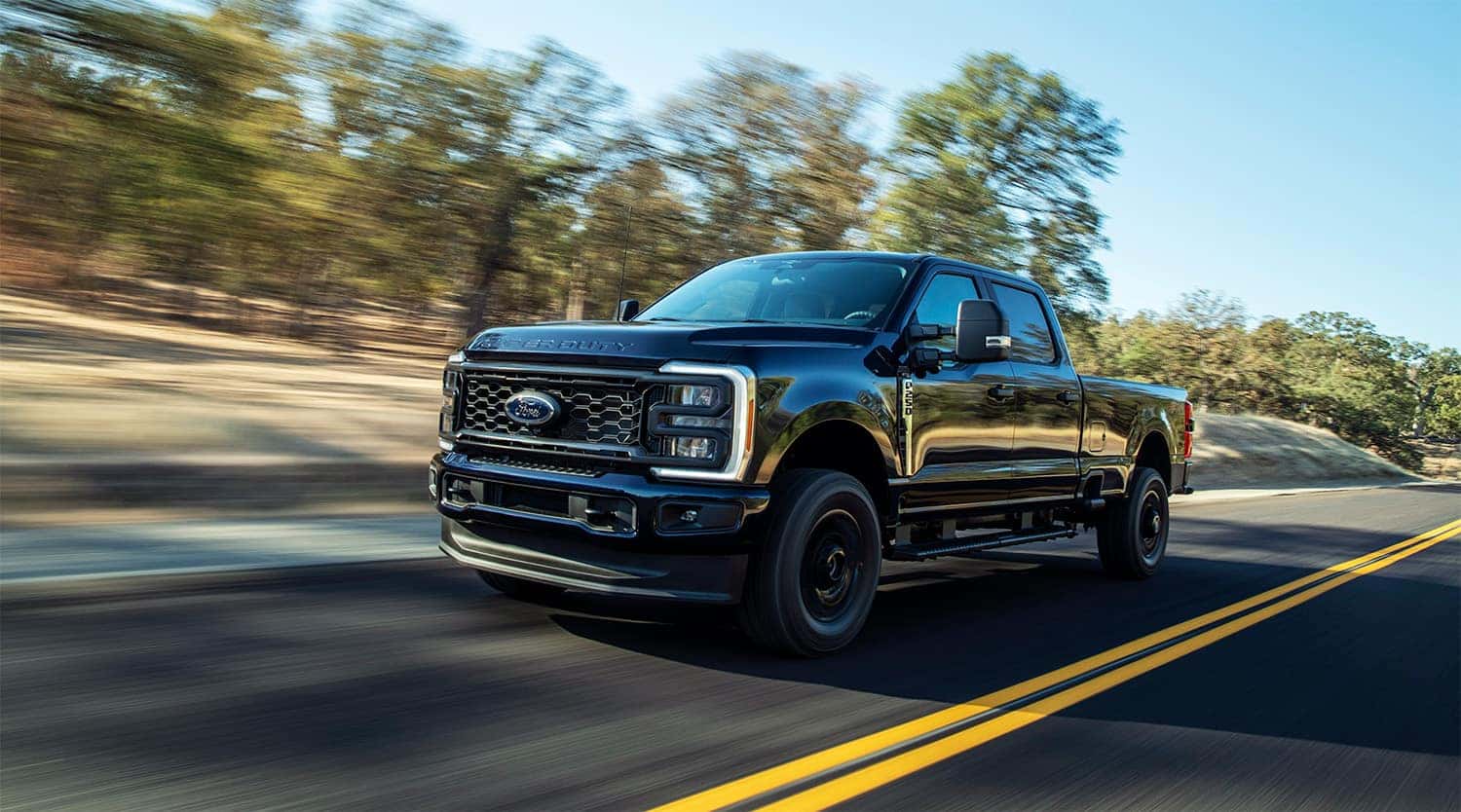 Ford F-250 Super Duty driving down scenic road with motion blur