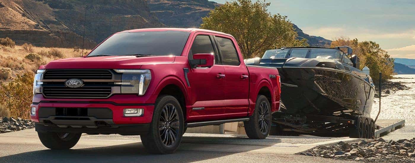 Red 2026 Ford F-150 STX FX4 towing a boat out of the water