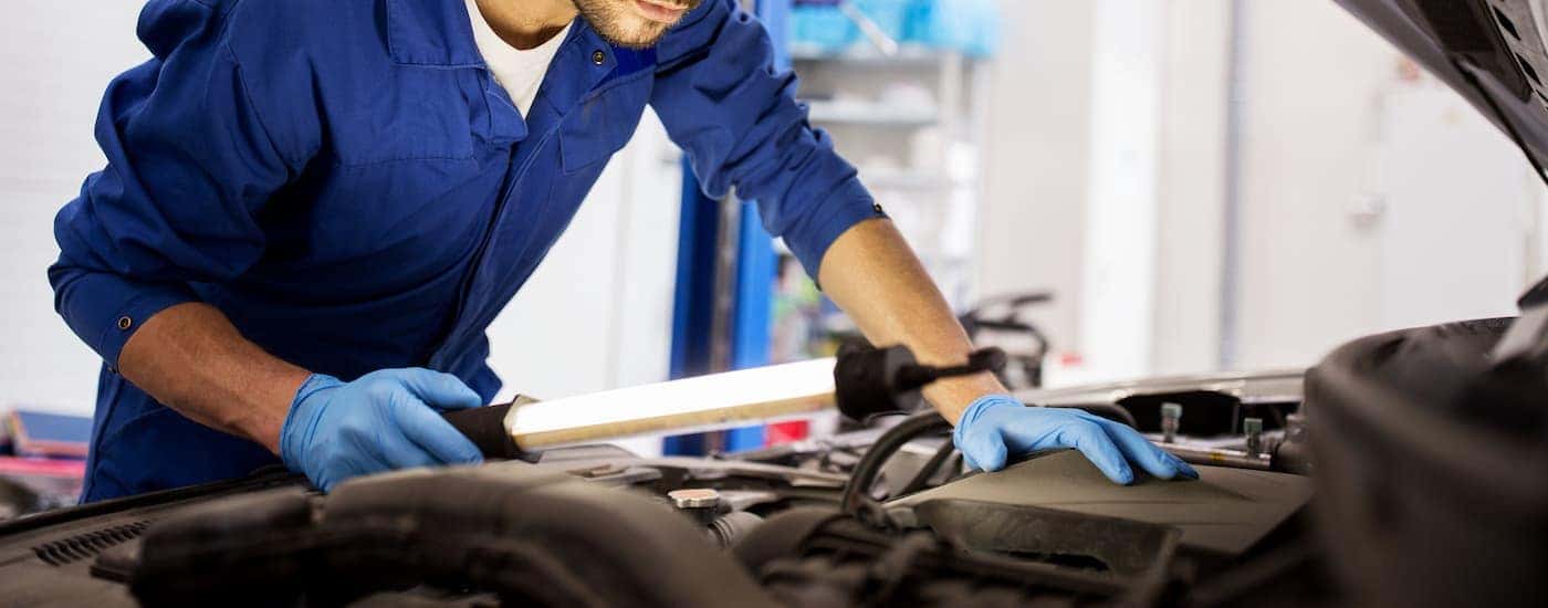 A service technician looking over the engine compartment