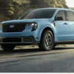 Front three-quarter view of a light blue 2026 Ford Maverick driving on a paved road.