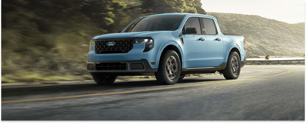 Front three-quarter view of a light blue 2026 Ford Maverick driving on a paved road.