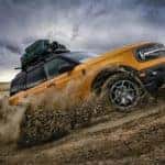 2022 yellow ford bronco climbing or driving up a hill aggressively