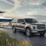 2022 gray ford f150 in motion towing a boat on the road