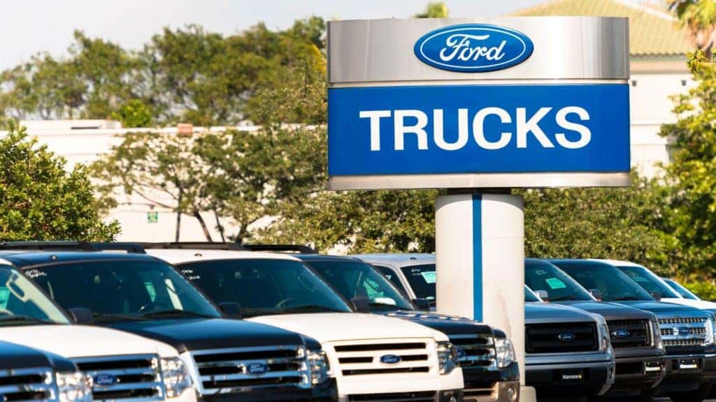 a row of used ford vehicles parked outside of a ford dealership