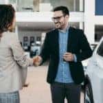 A customer shakes hands with a salesman at a Certified Ford Dealership.