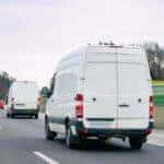 The back of a Ford Transit Connect driving down a highway.